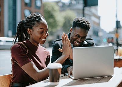 African American couple high-fiving at computer